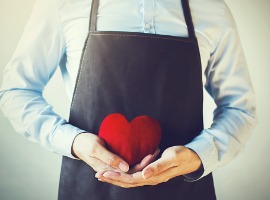 servicing man in apron holding open armed heart with hands