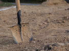 dirty closeup spade in dry clay soil view from above space for text picture