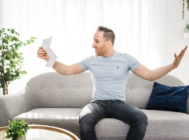 shocked man holding some documents on sofa livingroom picture