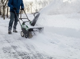 snow blower in action clearing a residential driveway after snow picture