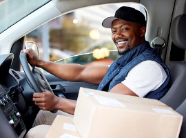 shot of young man delivering a package while sitting in a vehicle