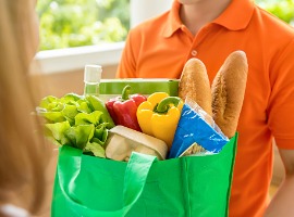 grocery store delivey man delivering food to a woman at home