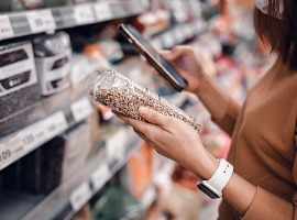 woman shopping in supermarket and reading product information costumer buying food at the