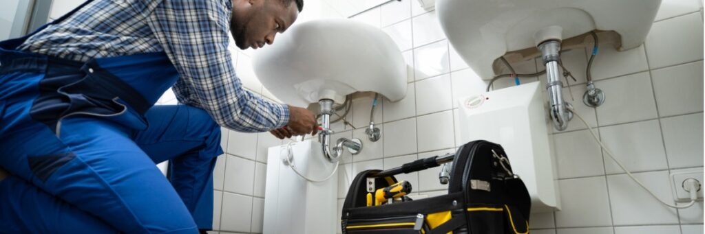 plumber fixing pipe in bathroom plumbing maintenance