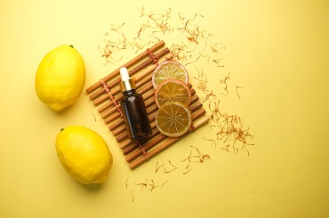 essential oil bottle and lemon on yellow background picture