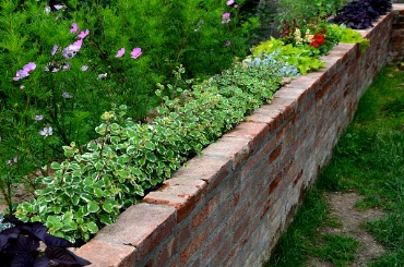 rugged backyard with brick walls and flower pots alcoves for benches picture