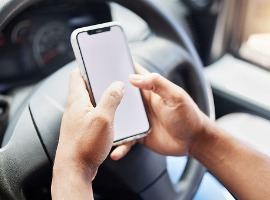 closeup shot of an unrecognisable delivery man using a cellphone while driving in a car