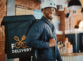 handsome black african american food delivery courier posing in front of the camera