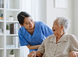 young asian woman nurse caregiver carer of nursing home talking with senior asian woman