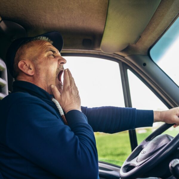 mature truck diver feeling tired and yawning during the ride