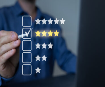 Man holding a stylus pointing at a checkbox in front of him indicating a four out of five-star review